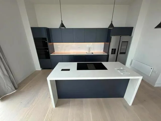 Elevated view of the kitchen island, pendant lights and illuminated splashback.