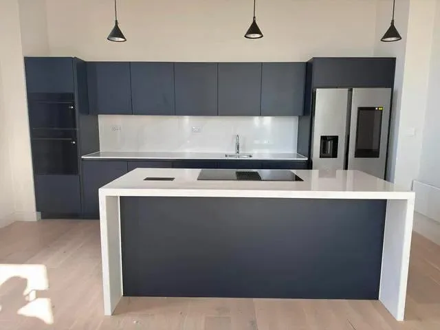 Apartment kitchen with dark cabinets and a central island.