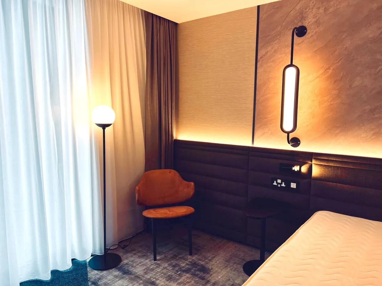 Hotel bedroom with a fitted headboard, desk and chair.