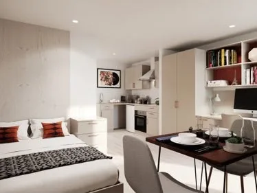 Student studio with a bed, dining table and kitchenette.